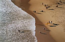 Auf dem Bild sieht man einen Strand in Portugal mit Surfern aus der Vogelperspektive.